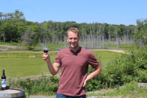 man holding up glass of wine on blueberry hill