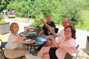 two couples on an outdoor patio sampling wine