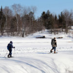 two people snowshoeing on a sunny winter day