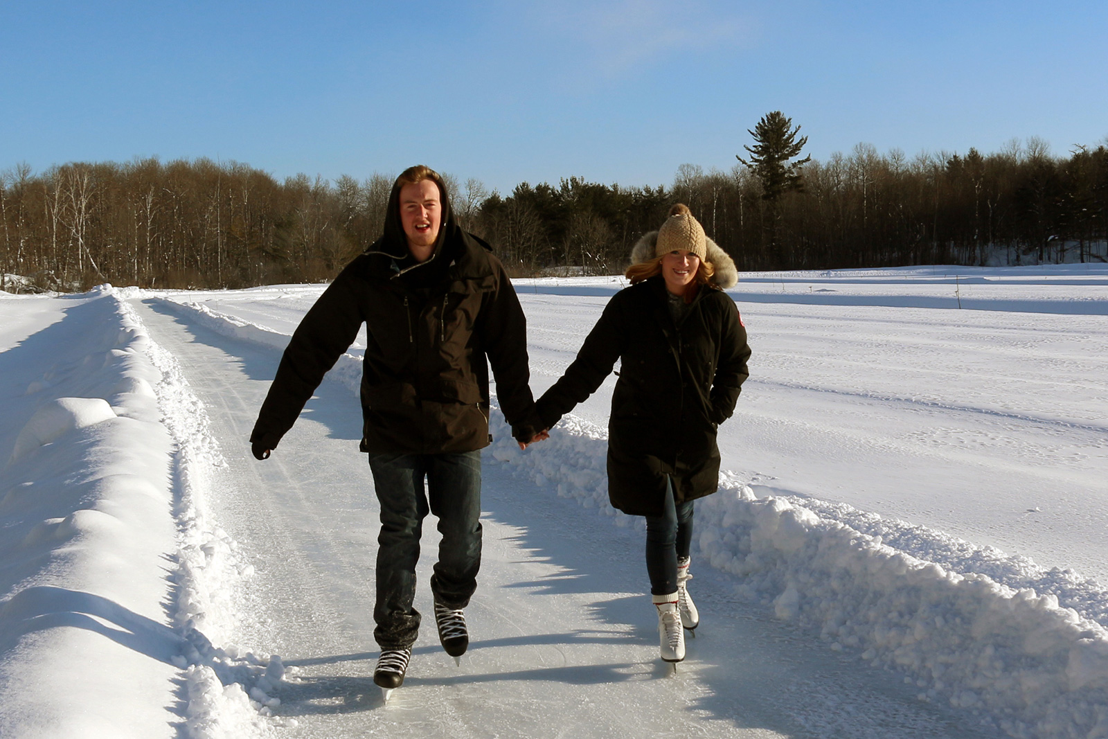 young couple skating the ice trail hand in hand