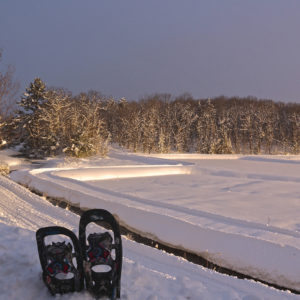 pair of snowshoes with old marsh sunrise in the background