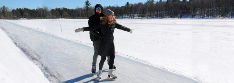 couple skating on outdoor ice trail