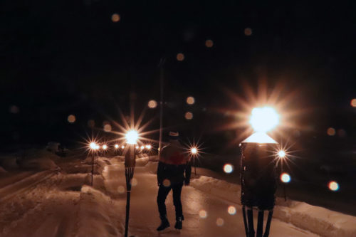 skater ready to skate the ice trail surrounded by torches for night skating