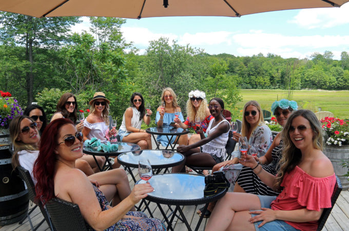 group of women drinking wine on muskoka lakes farm and winery patio