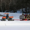 people in a sleigh being pulled by a tractor