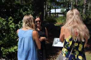 guide talking to two girls by a tour stop sign