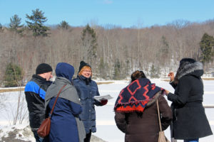 guide talking to four people outside in winter