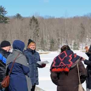guide talking to four people outside in winter