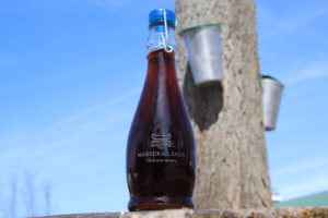 muskoka lakes maple syrup with sap buckets in the background