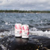 two cans of muskoka lakes cranberry splash wine spritzer on a rock in waves