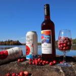 muskoka lakes cranberry wine and cider on a rock with lake in the background