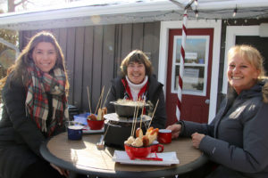 three women at an outdoor table with fondue