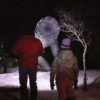 two people looking at the bala bog monster at night in winter